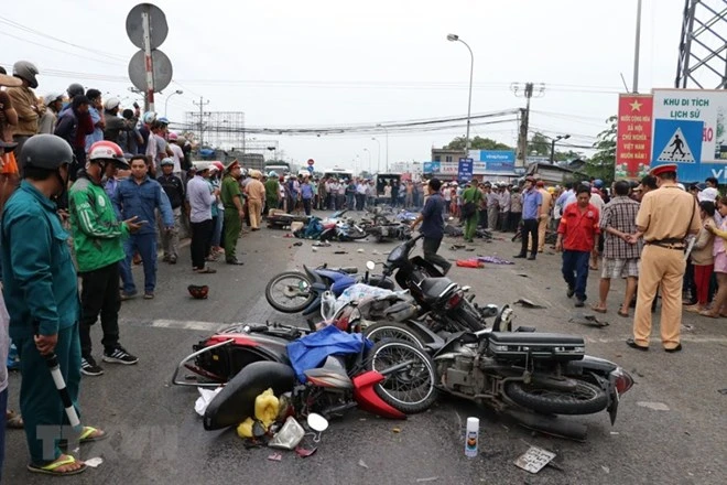 Hiện trường vụ tai nạn giao thông thảm khốc xe container đâm hàng loạt xe máy tại Long An làm nhiều người thương vong. (Ảnh: Bùi Giang/TTXVN)