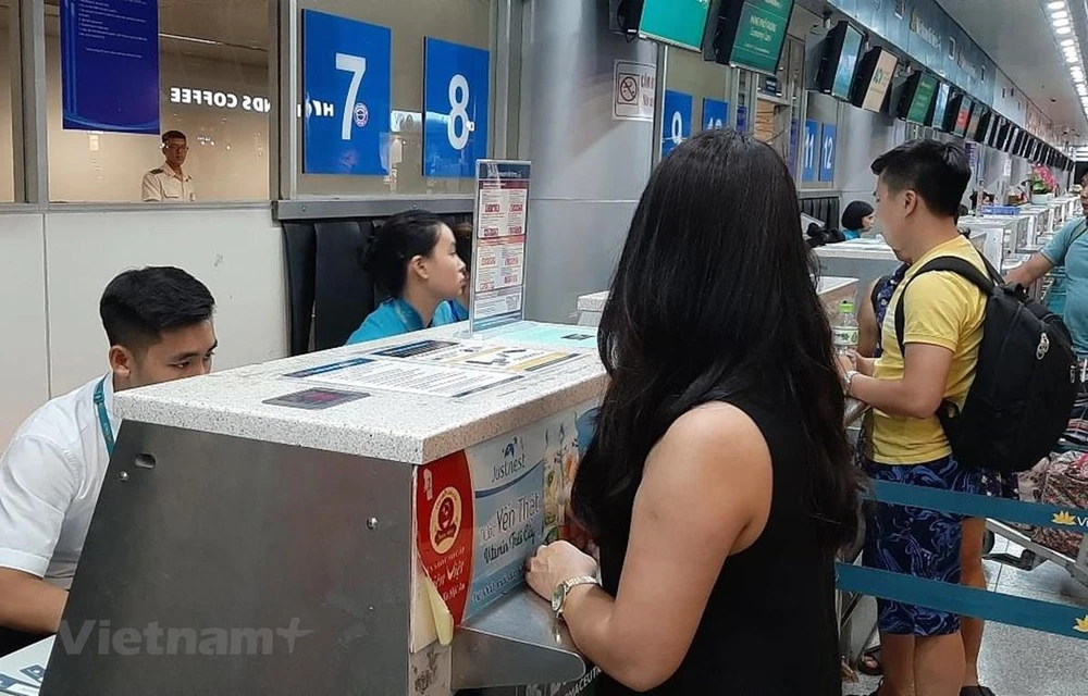 Hành khách mua vé máy bay của Vietnam Airlines. (Ảnh: Việt Hùng/Vietnam+)