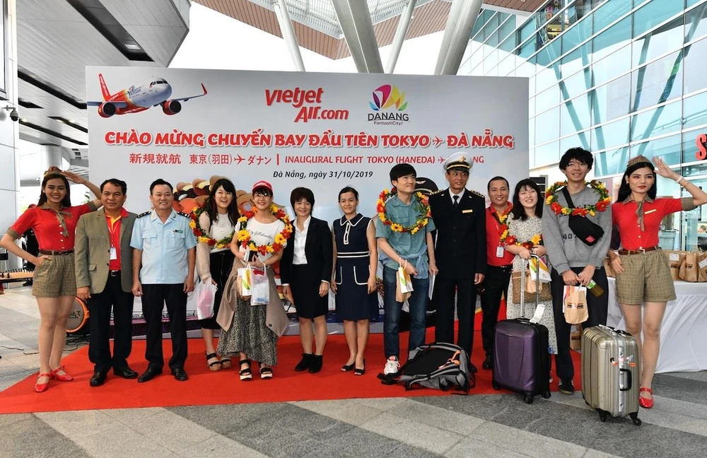 Tặng hoa cho những hành khách đầu tiên trên chuyến bay mới mở Đà Nẵng-Tokyo của hãng hàng không Vietjet. (Ảnh: CTV/Vietnam)