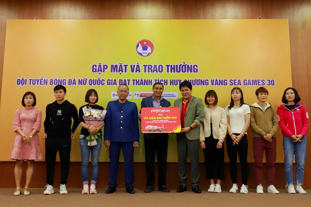 Ban huấn luyện các cầu thủ đội tuyển bóng đá nữ Việt Nam nhận phần quà 1 năm bay miễn phí từ hãng hàng không Vietjet. (Ảnh: CTV/Vietnam+)
