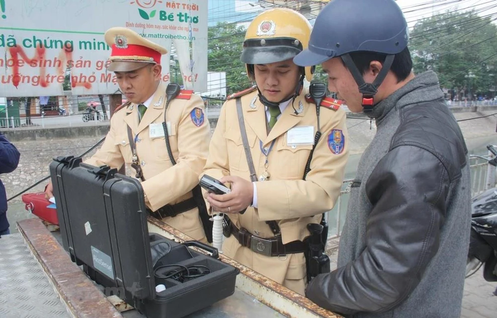 Cảnh sát giao thông tiến hành đo nồng độ cồn đối với người điều khiển phương tiện. (Ảnh: Việt Hùng/Vietnam+)