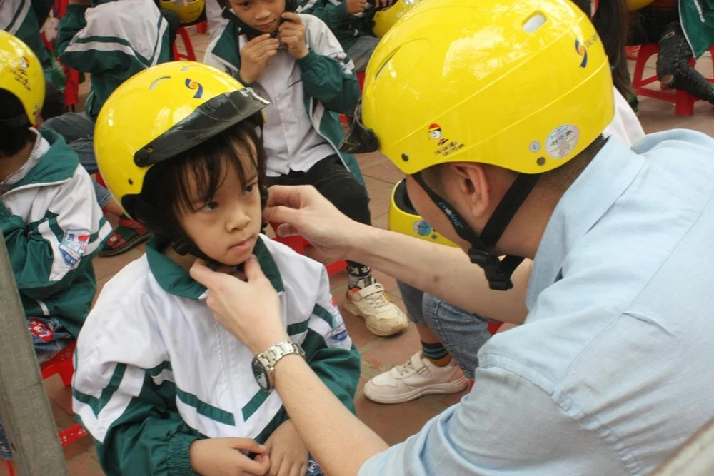 Trẻ em được đội mũ bảo hiểm đạt chuẩn sẽ giảm tỷ lệ chấn thương vùng đầu khi xảy ra tai nạn giao thông. (Ảnh: Việt Hùng/Vietnam+)