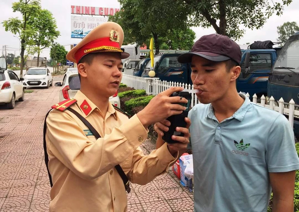 Cảnh sát giao thông tiến hành kiểm tra đo nồng độ cồn đối với lái xe. (Ảnh: Việt Hùng/Vietnam+)