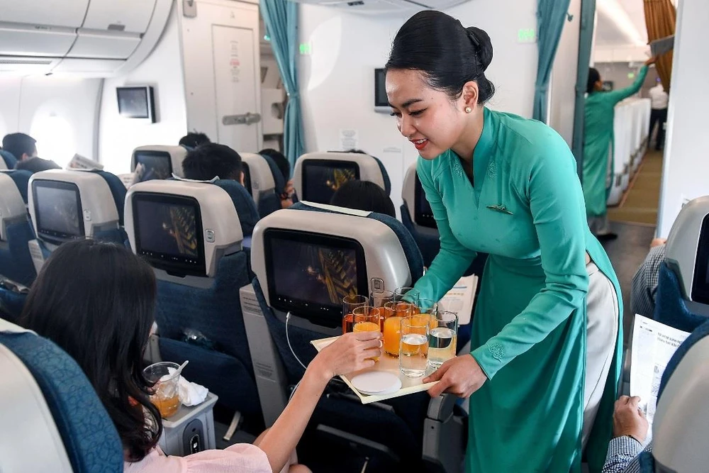 Tiếp viên phục vụ đồ uống trên chuyến bay của Vietnam Airlines. (Ảnh: CTV/Vietnam+)