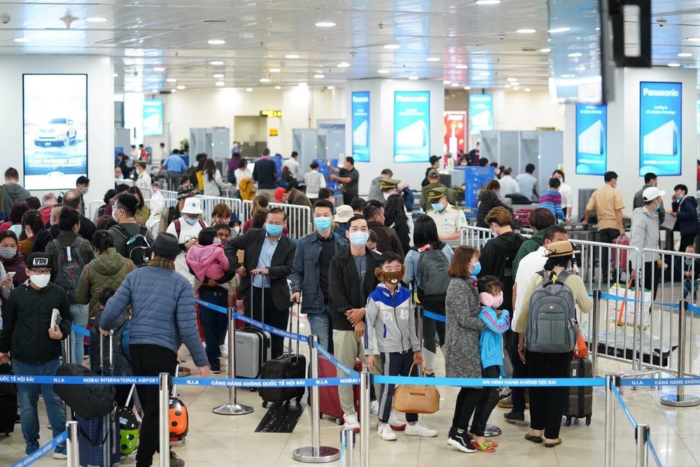 Hành khách tuân thủ việc đeo khẩu trang khi làm thủ tục chuyến bay tại Cảng hàng không quốc tế Nội Bài. (Ảnh: Phan Công/Vietnam+)