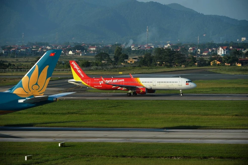 Máy bay của hãng hàng không Vietjet Air và Vietnam Airlines hạ cánh tại một sân bay. (Ảnh: Hoàng Anh/Vietnam+)