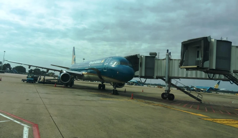 Hành khách Vietnam Airlines bay Hà Nội-Thành phố Hồ Chí Minh được phục vụ cửa lên máy bay có ống lồng. (Ảnh: Việt Hùng/Vietnam+)