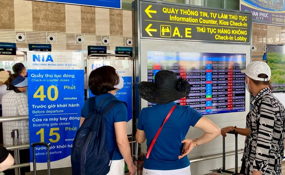 Hành khách theo dõi thông tin chuyến bay tại màn hình FIDS tại sân bay Nội Bài. (Ảnh: Văn phòng Cảng hàng không Nội Bài)