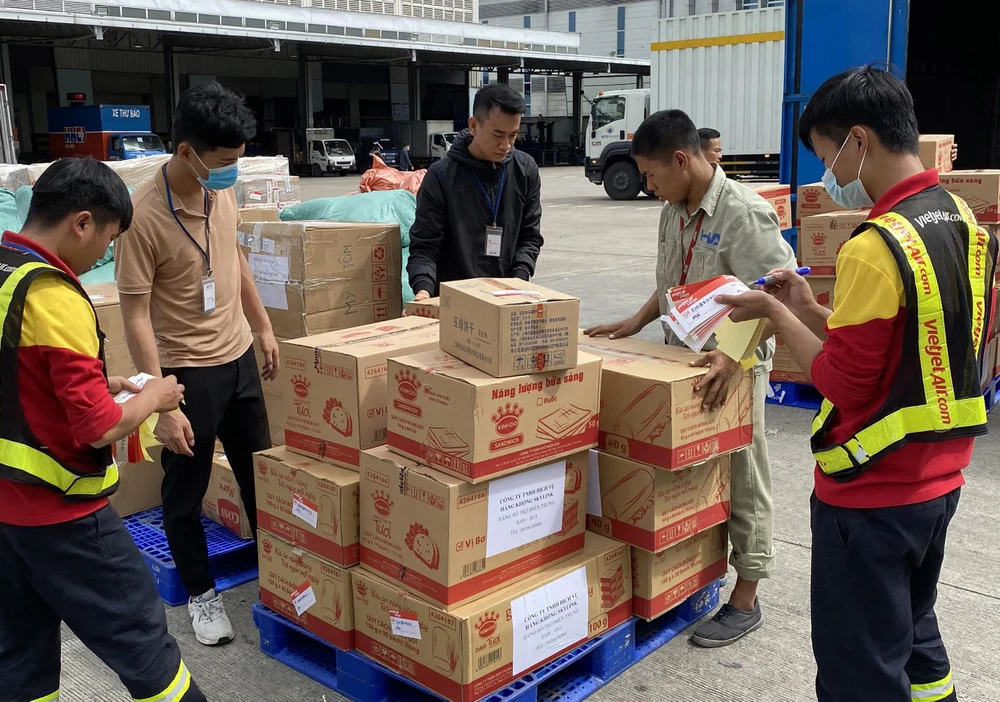Nhân viên Vietjet Air tiếp nhận hàng hóa cứu trợ vận chuyển miễn phí đến miền Trung. (Ảnh: CTV/Vietnam+)