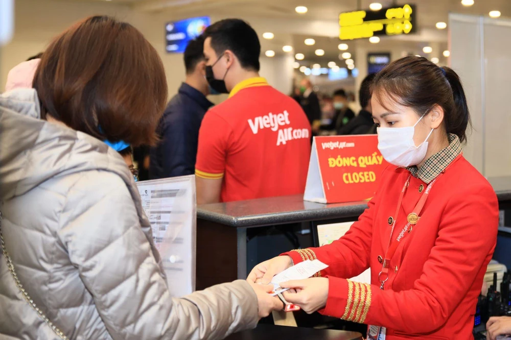 Hành khách mua vé bay và làm thủ tục chuyến bay của hãng hàng không Vietjet. (Ảnh: CTV/Vietnam+)
