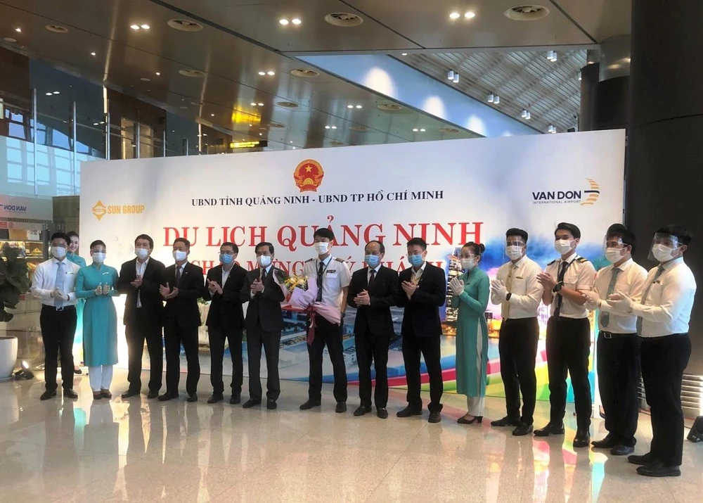 Lãnh đạo tỉnh Quảng Ninh và Vietnam Airlines tặng hoa cho phi hành đoàn chuyến bay Thành phố Hồ Chí Minh và Vân Đồn. (Ảnh: CTV/Vietnam+)