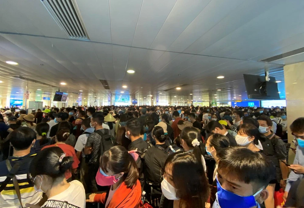 Hành khách xếp hàng dài chờ làm thủ tục lên máy bay tại sân bay Tân Sơn Nhất. (Ảnh: CTV/Vietnam+)