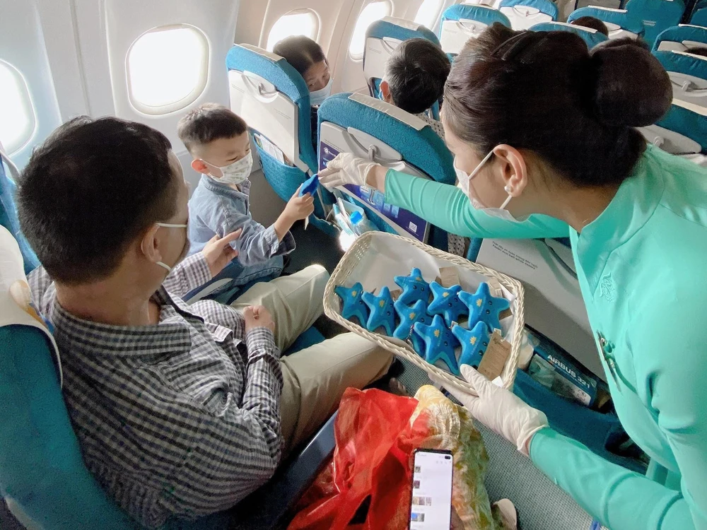 Hành khách “nhí” nhận món quà lưu niệm là chiếc móc khóa sao biển nhồi bông từ Vietnam Airlines trên chuyến bay tới Phú Quốc nhằm bảo vệ sao biển. (Ảnh: CTV/Vietnam+)