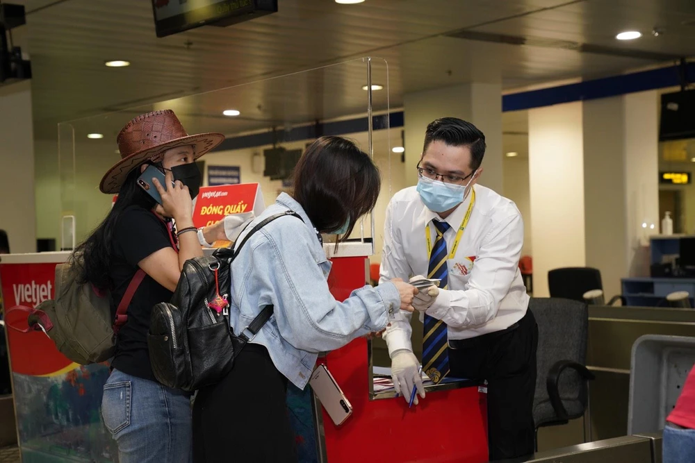 Hành khách làm thủ tục hàng không trên chuyến bay của Vietjet. (Ảnh: CTV/Vietnam+)