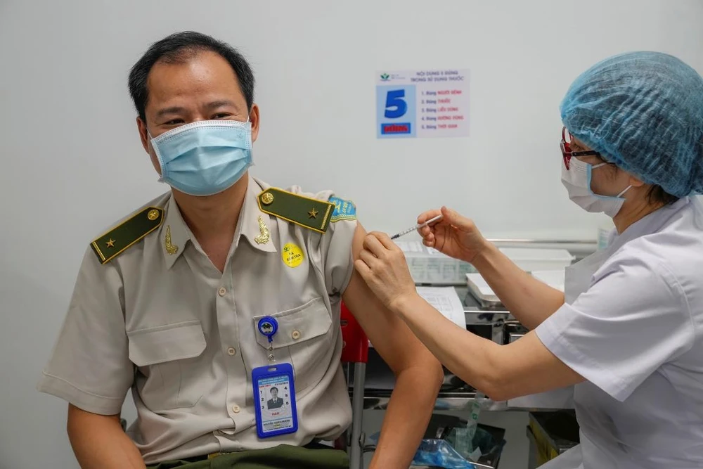 Nhân viên an ninh hàng không sân bay Nội Bài được tiêm vaccine COVID-19. (Ảnh: CTV/Vietnam+)