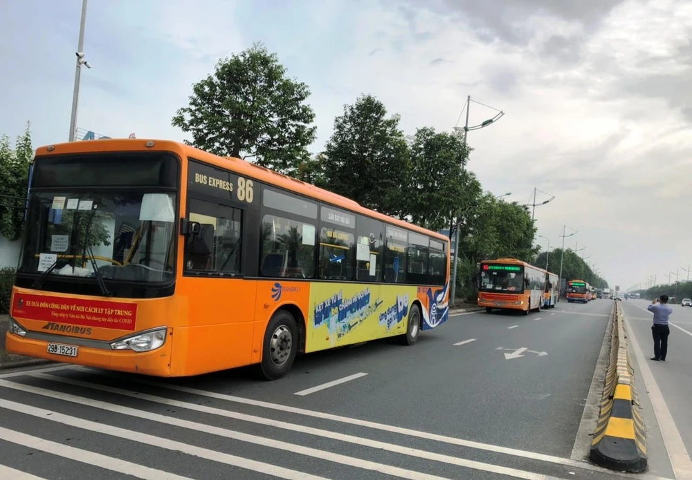 Transerco đã triển khai những chuyến xe đầu tiên đưa đón công dân từ sân bay Nội Bài đến các khu cách ly tập trung đối với những người dân từ các địa phương có dịch về Hà Nội. (Ảnh: CTV/Vietnam+)