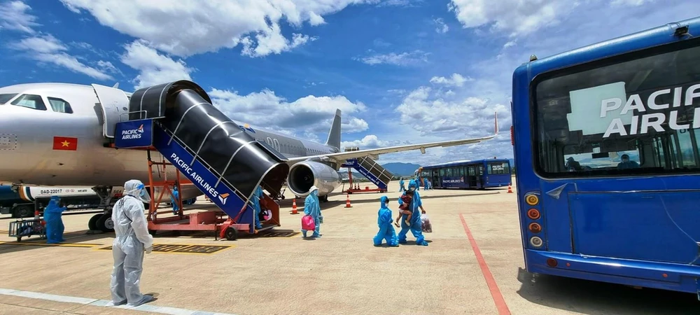Hành khách Quảng Nam xuống sân bay Đà Nẵng và được bố trí đưa về cách ly tập trung, bảo đảm quy trình khép kín phòng chống dịch. (Ảnh: CTV/Vietnam+)