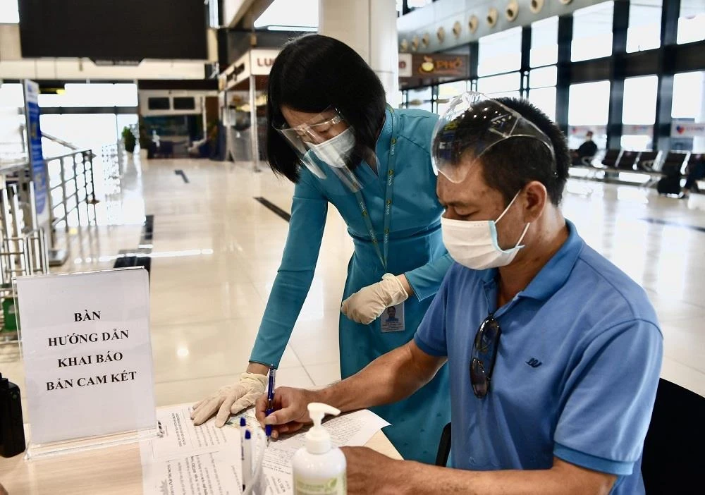 Hành khách đi máy bay làm thủ tục kê khai thông tin di chuyển nội địa để đảm bảo cho công tác phòng, chống dịch COVID-19. (Ảnh: CTV/Vietnam+)