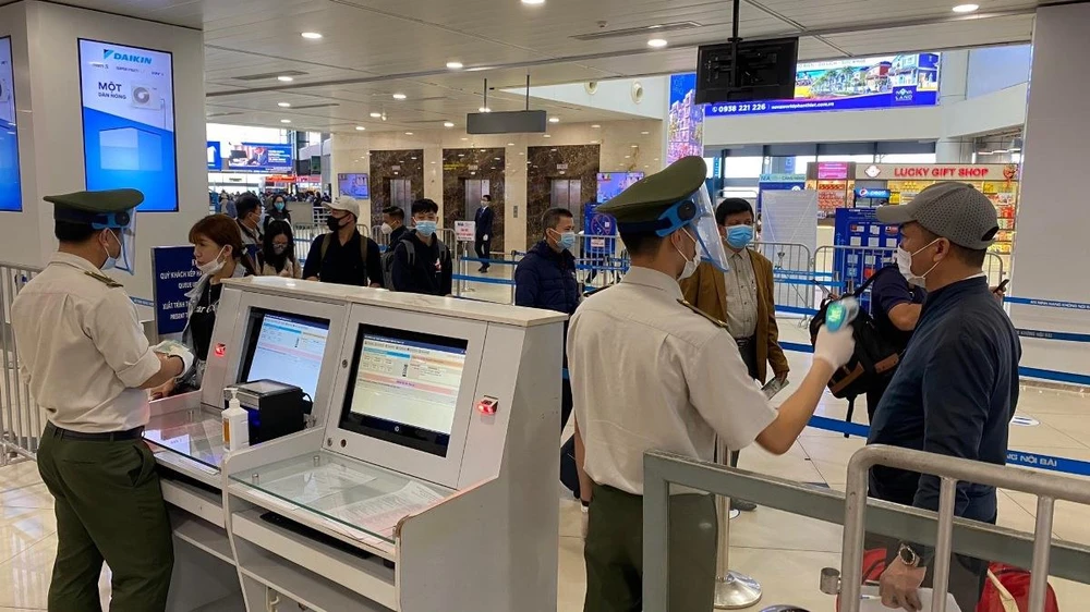 Nhân viên an ninh hàng không kiểm tra hành khách khi làm thủ tục hàng không để lên máy bay. (Ảnh: CTV/Vietnam+)