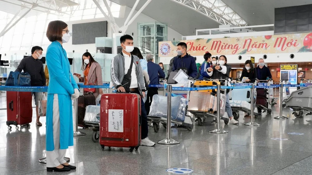Hành khách đang làm thủ tục lên chuyến bay tại sân bay Nội Bài. (Ảnh: CTV/Vietnam+)