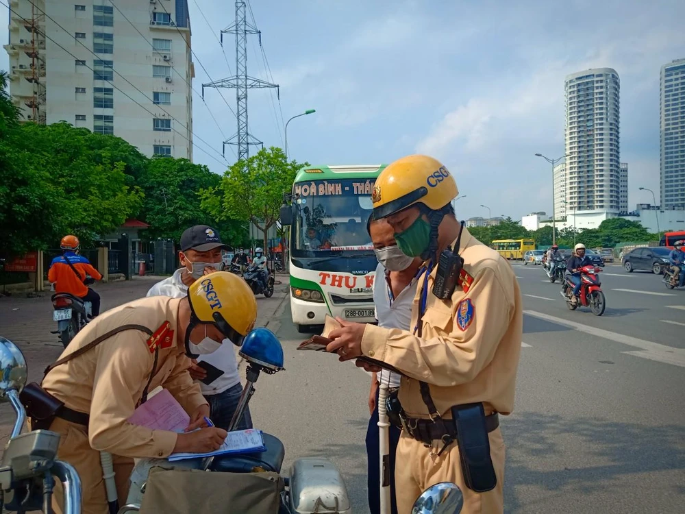 Lực lượng Cảnh sát giao thông tiến hành kiểm tra, xử lý xe khách vi phạm quy định về giao thông. (Ảnh: CTV/Vietnam+)