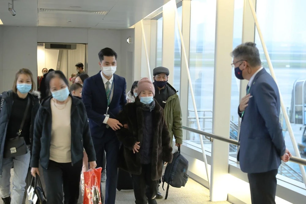 Phó Tổng Giám đốc Bamboo Airways Trương Phương Thành chào đón người Việt ở Ukraine về nước từ Ba Lan tại sân bay Nội Bài. (Ảnh: CTV/Vietnam+)