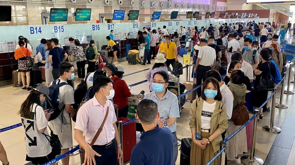 Hành khách làm thủ tục trước chuyến bay tại sân bay Nội Bài. (Ảnh: CTV/Vietnam+)