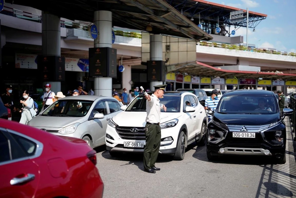 Lực lượng An ninh sân đỗ ôtô tăng cường điều tiết trong điều kiện nắng nóng, giữa dòng xe nối đuôi nhau từ sáng sớm đến đêm muộn. (Ảnh: CTV/Vietnam+)