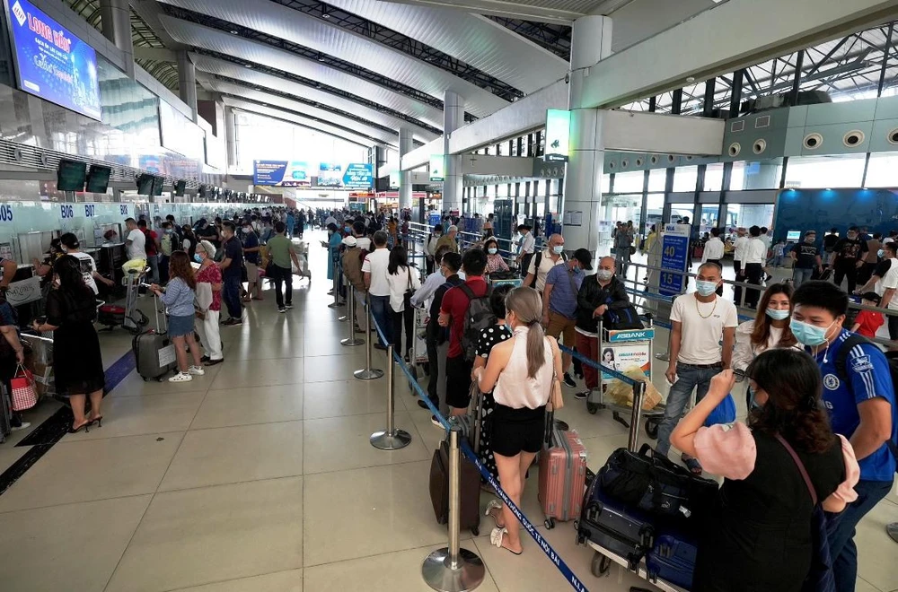 Hành khách xếp hàng dài làm thủ tục chuyến bay. (Ảnh: CTV/Vietnam+)