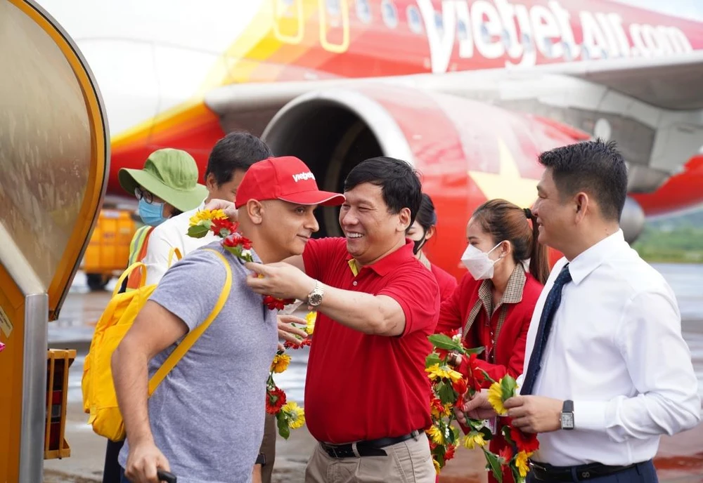 Lãnh đạo tỉnh Kiên Giang và Vietjet tặng hoa du khách trên chuyến bay từ quốc gia 1,4 tỷ dân Ấn Độ tới với Phú Quốc. (Ảnh: CTV/Vietnam+)