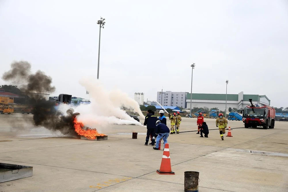 Các lực lượng tham gia diễn tập khống chế và dập đám cháy sau sự cố tràn nhiên liệu từ máy bay. (Ảnh: CTV/Vietnam+)