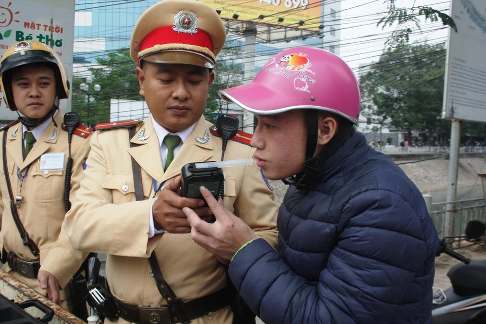 Lực lượng Cảnh sát giao thông kiểm tra đo nồng độ cồn của lái xe máy. (Ảnh: Việt Hùng/Vietnam+)