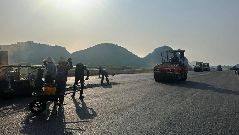 Nhà thầu thi công dải thảm lớp bê tông nhựa dự án cao tốc Bắc-Nam đoạn Mai Sơn-Quốc lộ 45 nhằm thông xe kỹ thuật vào ngày 31/12/2022. (Ảnh: Việt Hùng/Vietnam+)