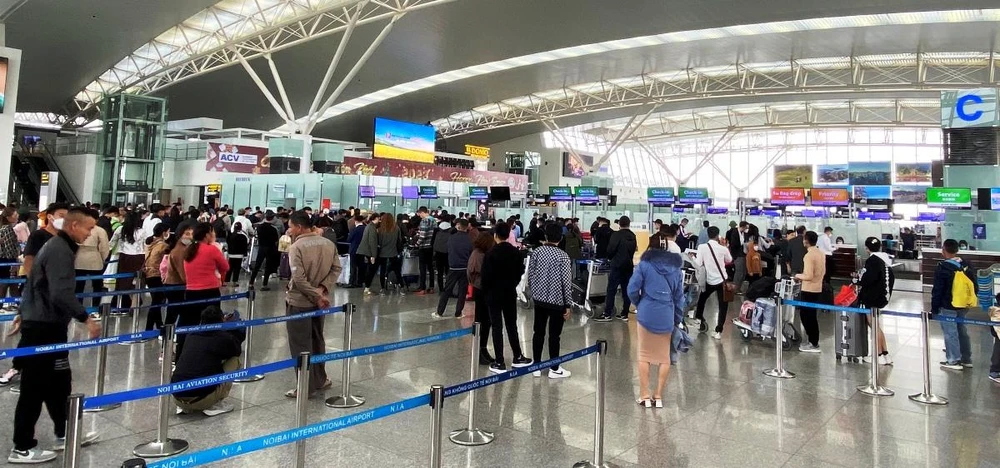 Hành khách làm thủ tục tại sân bay Nội Bài. (Ảnh: CTV/Vietnam+)