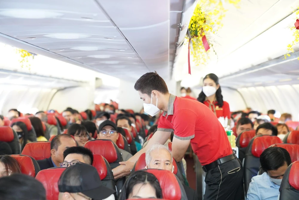 Tiếp viên của hãng hàng không Vietjet phục vụ hành khách trên một chuyến bay. (Ảnh: CTV/Vietnam+)