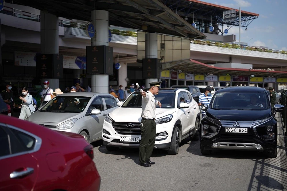 Lực lượng an ninh sân đỗ ôtô tăng cường điều tiết phương tiện ra, vào Cảng hàng không quốc tế Nội Bài. (Ảnh: CTV/Vietnam+)