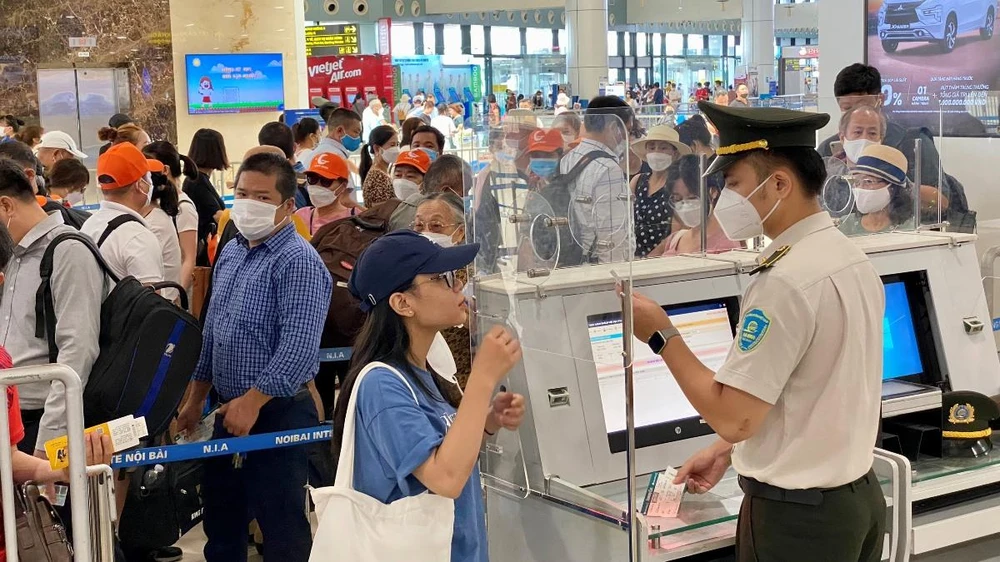Nhân viên An ninh hàng không kiểm tra giấy tờ hành khách đi máy bay trước khi vào điểm soi chiếu an ninh. (Ảnh: CTV/Vietnam+)