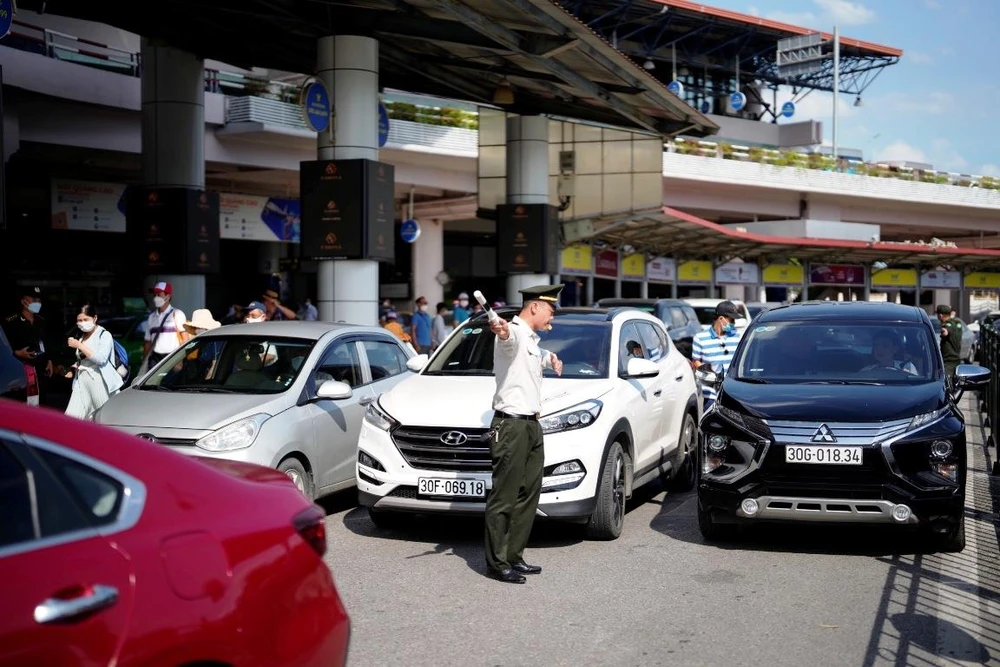 Lực lượng an ninh sân đỗ ôtô tăng cường điều tiết phương tiện ra, vào Cảng hàng không quốc tế Nội Bài. (Ảnh: CTV/Vietnam+)