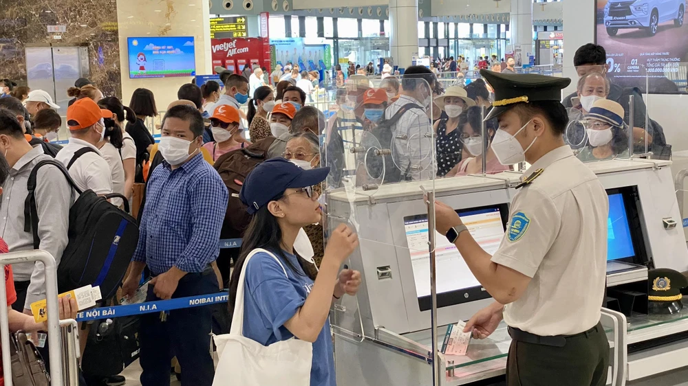 Nhân viên an ninh hàng không kiểm tra xác thực hành khách trước khi vào kiểm tra soi chiếu an ninh tại sân bay Nội Bài. (Ảnh: CTV/Vietnam+)