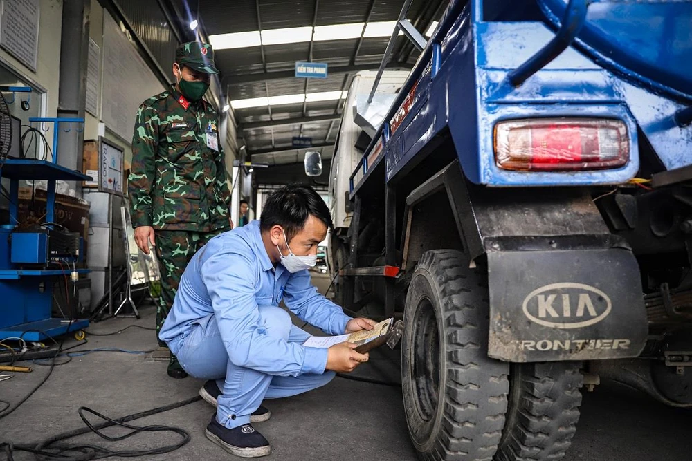 Nhân viên đăng kiểm thực hiện quy trình kiểm định xe cơ giới tại trung tâm đăng kiểm ở Hà Nội. (Ảnh: Hoài Nam/Vietnam+)