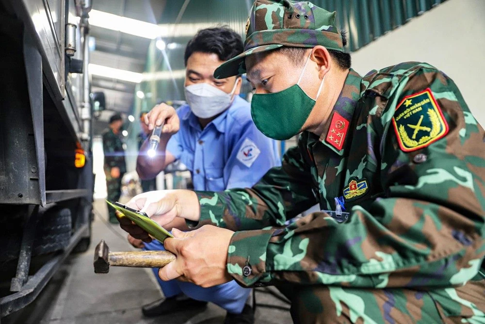 Kiểm tra giấy chứng nhận đăng kiểm của phương tiện đến kiểm định. (Ảnh: Hoài Nam/Vietnam+)