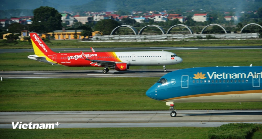 Máy bay của hai hãng hàng không Vietnam Airlines và Vietjet đang chuẩn bị cất, hạ cánh tại một sân bay. (Ảnh: PV/Vietnam+)