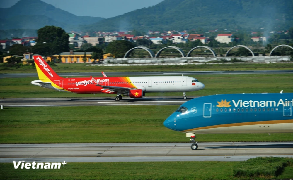 Máy bay của hai hãng hàng không Vietnam Airlines và Vietjet đang chuẩn bị cất, hạ cánh tại một sân bay. (Ảnh: PV/Vietnam+)