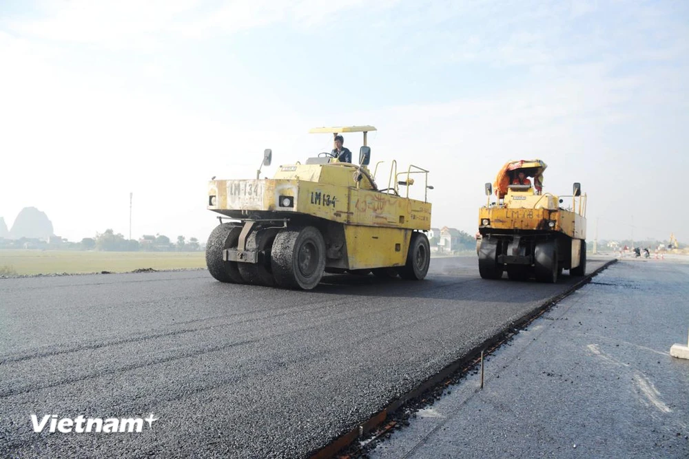 Nhà thầu thi công thảm nhựa mặt đường Dự án đường cao tốc. (Ảnh: Việt Hùng/Vietnam+)