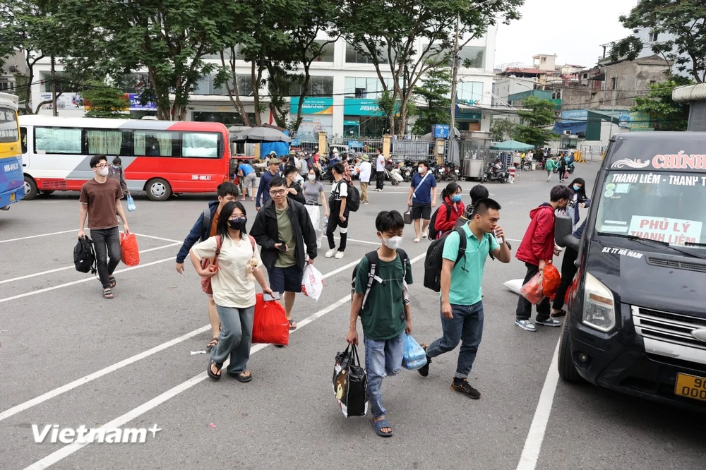 Người dân tay xách lỉnh kỉnh đồ đạc từ các tỉnh thành trở về Thủ đô trong ngày cuối của đợt nghỉ lễ 30/4-1/5. (Ảnh: Hoài Nam/Vietnam+)