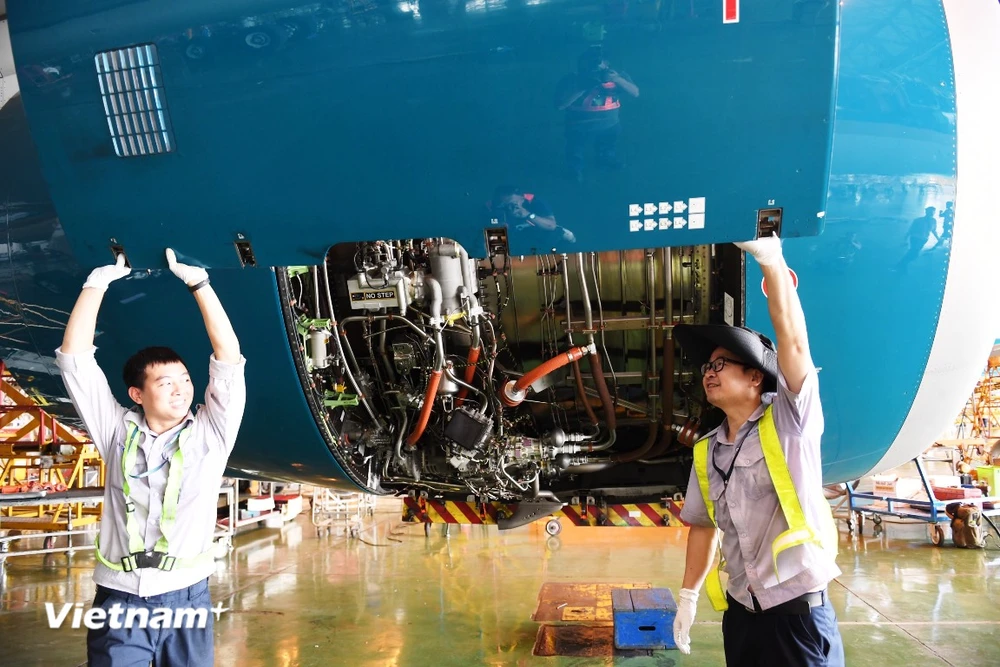 Nhân viên hàng không thực hiện bảo dưỡng máy bay của Vietnam Airlines. (Ảnh: PV/Vietnam+)