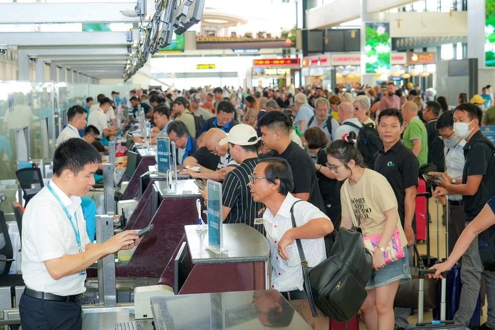 Hành khách làm thủ tục chuyến bay trong dịp cao điểm Hè 2024. (Ảnh: PV/Vietnam+)