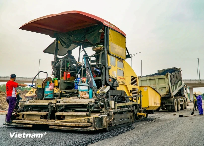 Nhà thầu thực hiện bảo trì một tuyến đường bộ. (Ảnh: Minh Hiếu/Vietnam+) 