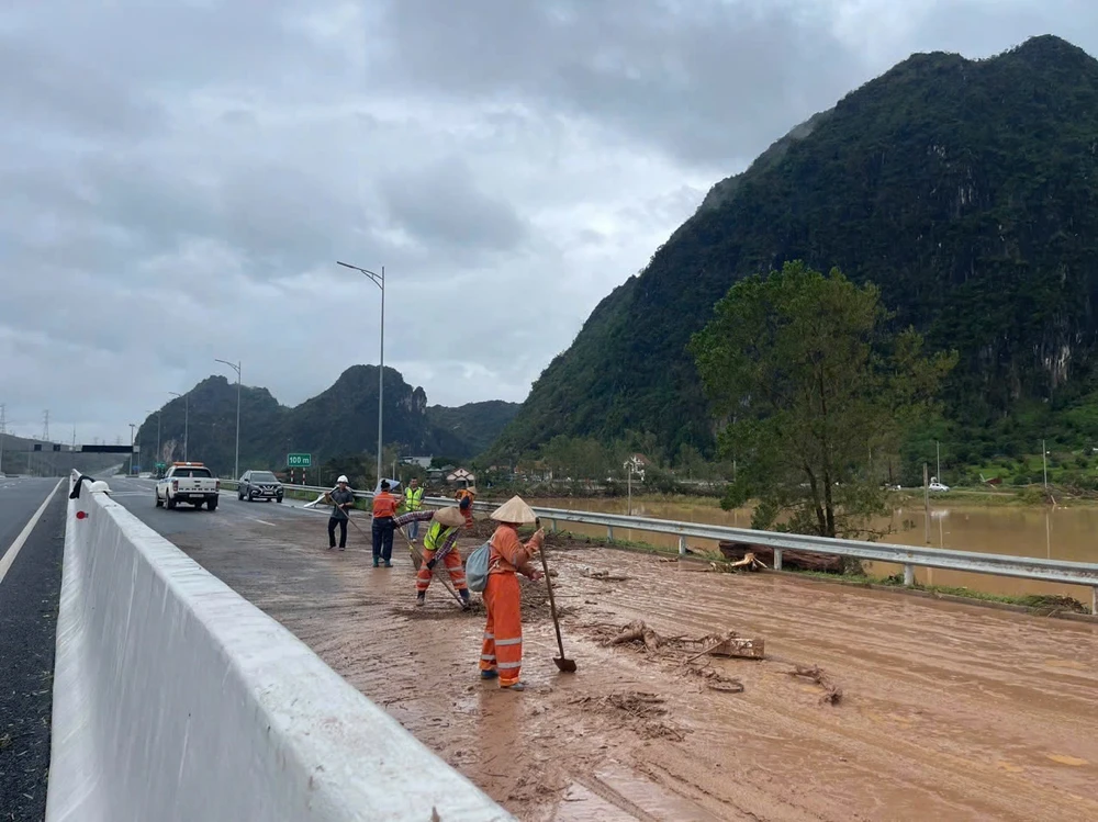 Nhân công nhân nỗ lực dọn dẹp, làm sạch đường trước khi thông bên trái hướng từ Đồng Lá đi Việt Hưng trên cao tốc Hạ Long-Móng Cái. (Ảnh: PV/Vietnam+)