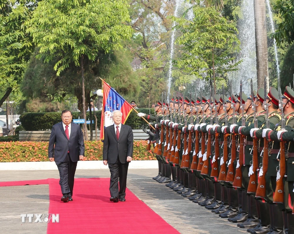 Tổng Bí thư, Chủ tịch nước Lào Bounnhang Vorachith và Tổng Bí thư, Chủ tịch nước Nguyễn Phú Trọng duyệt đội danh dự Quân đội nhân dân Lào tại lễ đón chính thức. (Ảnh: Trí Dũng/TTXVN) 